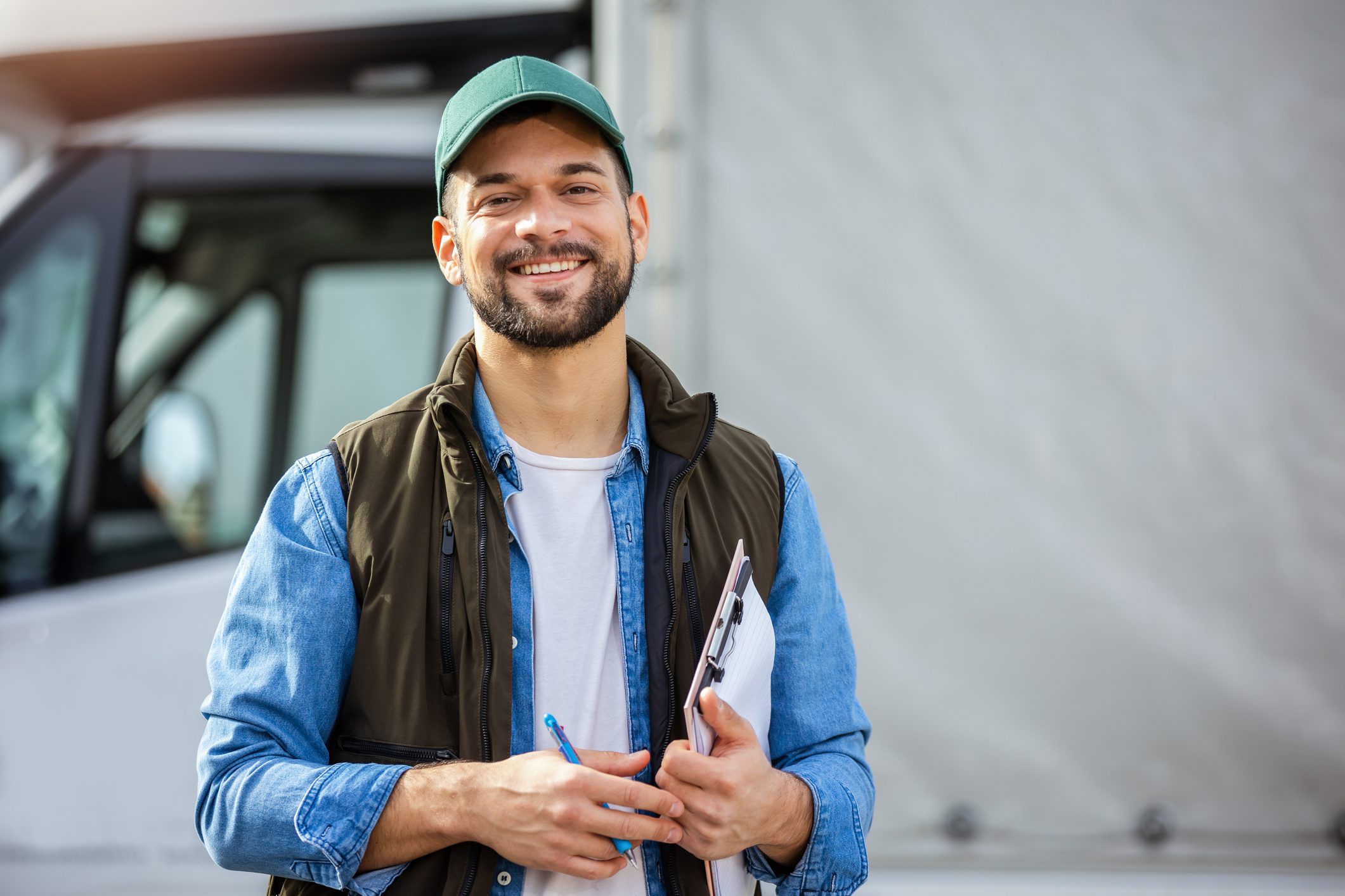 Happy confident male driver standing in front on his truck Happy confident male driver standing in front on his truck